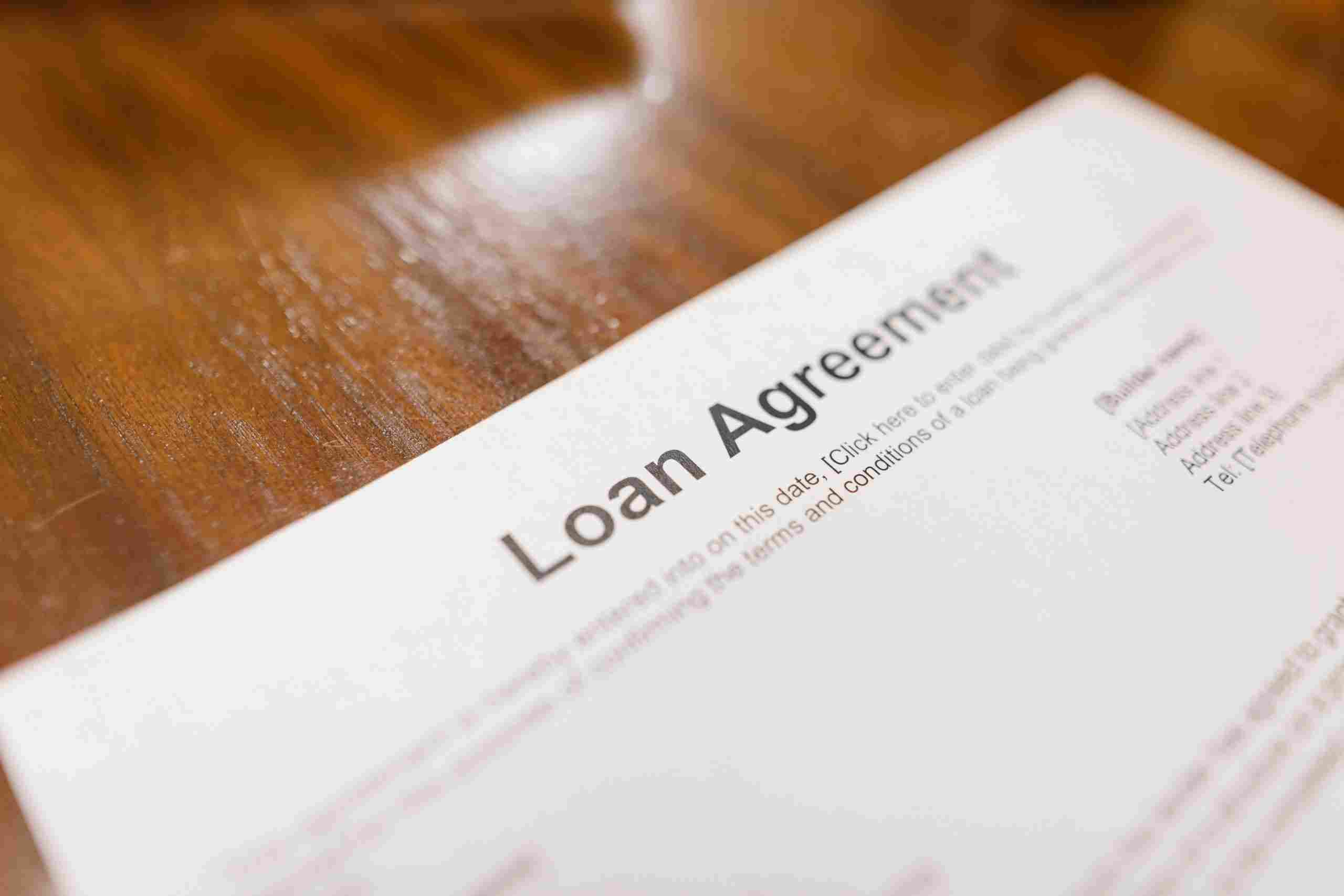 Loan agreement document on a wooden desk representing Restaurant improvement loans, commercial refrigerator financing, restaurant development financing, and restaurant location expansion loans for restaurant owners seeking funding for renovations, equipment upgrades, and business growth.